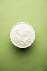 Plain curd or yogurt or Dahi in Hindi, served in a bowl over moody background. Selective focus