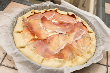 horizontal image with top view of preparation a savory pie with ham