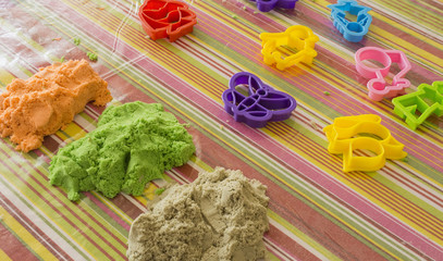 horizontal image of an educational game with magical sand and molds of various colors