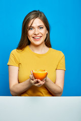 Woman holding orange fruit. Smiling girl portrait