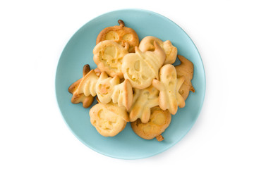Homemade Halloween cookies in blue plate isolated on white background. Top view.