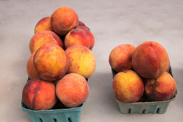 Three green pint containers of peaches on white table