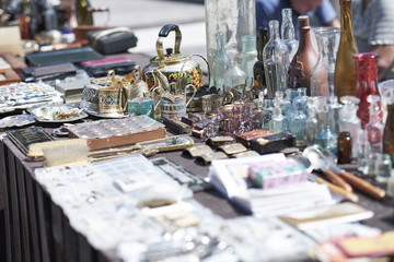Market boot with objects beeing selled at the weekend flea market in the city center. Curious visitors in the background