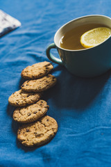 Tea with Lemon and Cookies with Chocolate Laying on Mattress