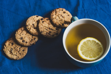 Tea with Lemon and Cookies with Chocolate Laying on Mattress