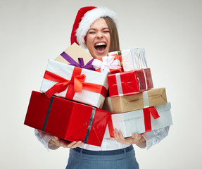 Happy woman wearing santa hat holding pile of gifts.