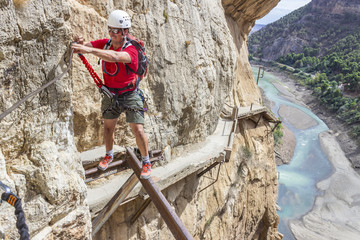 One person in the amazing famous "Caminito del Rey" a path at 100m above the ground on a steep gorge called "Desfiladero de los Gaitanes", best trekkings in Andalusia and Spain, an awesome adventure