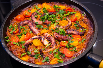 Paella with octopus on the pan