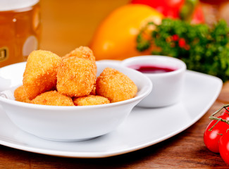 Deep fried cheese with berry sauce on white plate. Close up