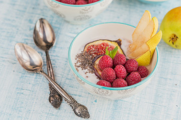 Smoothie bowl with fresh fruits, chia seeds, raspberry and fig