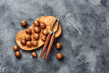 Unshelled macadamia nuts on gray background with copy space. Top view.