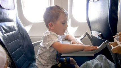 Toend portrait of cute 2 years old toddler boy sitting in airplane
