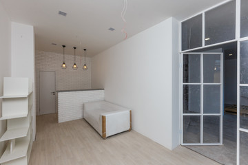 Interior empty office light room with white wallpaper without furniture in a new building renovation or under construction.Glass doors and Windows.