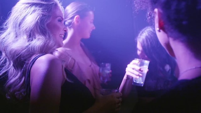 Beautiful woman dancing at disco with friends