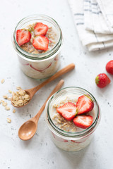 Overnight oatmeal or strawberry overnight oats in a jar on concrete background. Selective focus,...