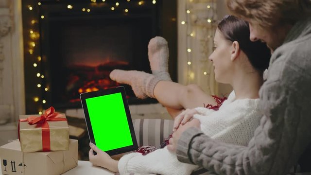 Happy couple choosing New Year presents in online store