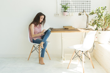 People, technology and internet concept - young woman using digital tablet at home