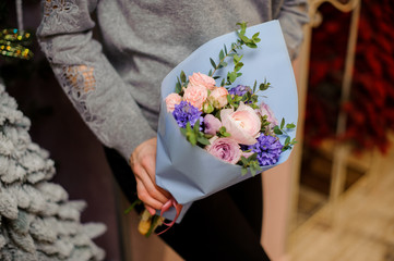 Young girl holding a bouquet of tender pink and blue flowers