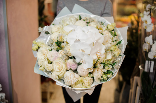 Young girl holding a huge bouquet of tender white flowers