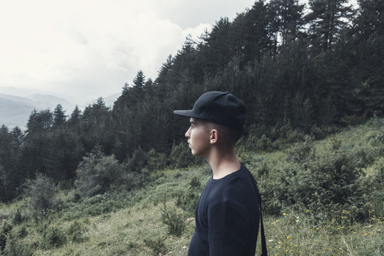 portrait of young hiker with black cap watching to the valley