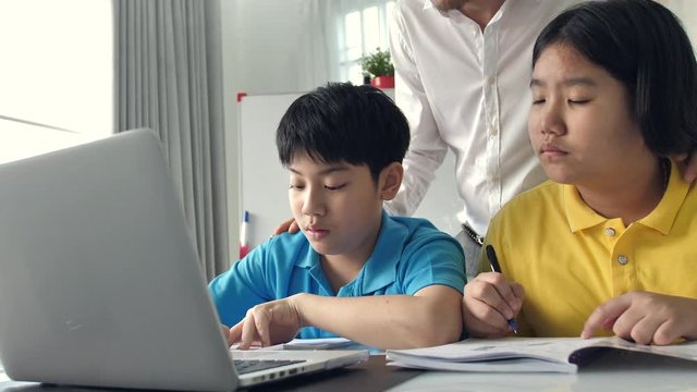 Tutor room children in class learning on laptop computer with teacher. 4K Slow motion Asian child learning with teacher at home.