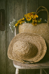 Closeup of sunflowers in straw purse on chair