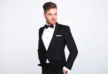 attractive man in black tuxedo standing with hands in pockets