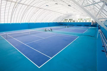 Zelfklevend Fotobehang Background shot of modern indoor tennis court interior in blue colors, copy space © Seventyfour