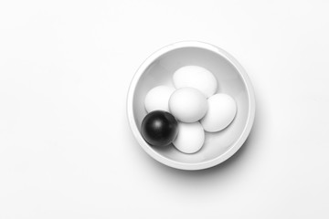 on a white background, white eggs and one black symbolizing diversity, separation, concretion and leadership