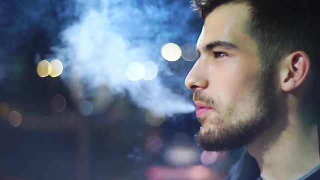 Young man smoking, night background light