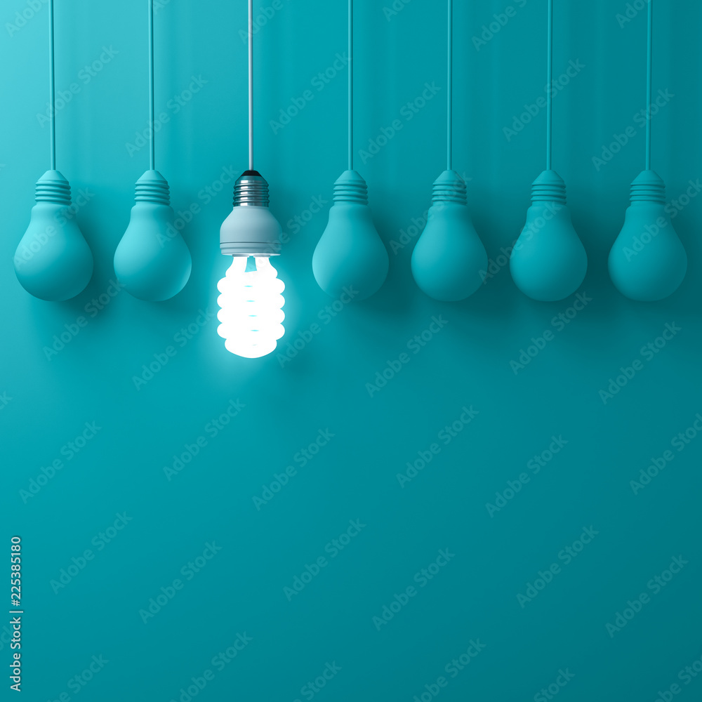 Poster one hanging eco energy saving light bulb glowing and standing out from unlit incandescent bulbs on d