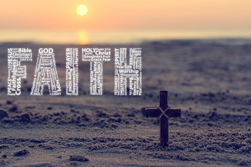 Christian cross on sand against beautiful golden sunrise and word faith in white written with christian words - obrazy, fototapety, plakaty