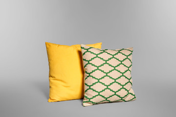 Two stylish decorative pillows on light background