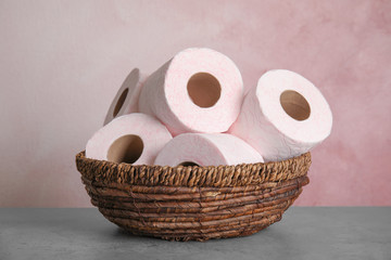 Wicker bowl with toilet paper rolls on table