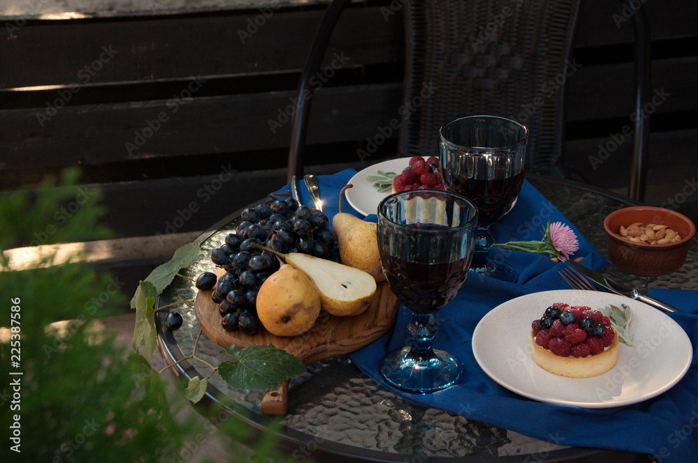 Wall mural Fruits, cakes and two glasses of wine.