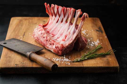 Raw rack of lamb with spices on a cutting board