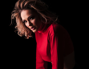 side view of sensual blonde woman in red top leaning