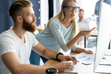 Confident and successful. Young modern colleagues in smart casual wear working while spending time in the office.