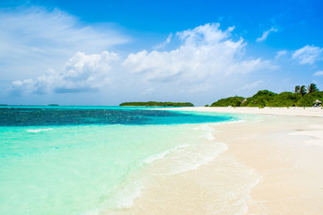 Beautiful sandy beach with sunbeds and umbrellas in Indian ocean, Maldives island