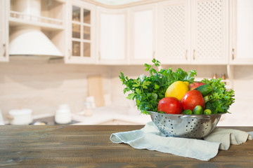 Modern kitchen with fresh vegetables on wooden tabletop, space for you and display products.