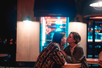 Young couple at the bar, street of the night city