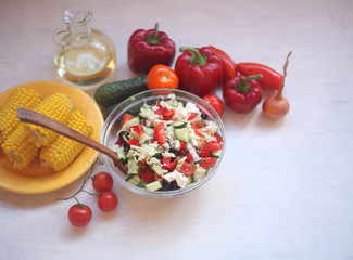 Greek salad ,boiled corn,oil and wine glasses/Mediterranean food