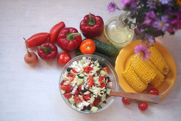 Greek salad ,boiled corn,oil and wine glasses/Mediterranean food