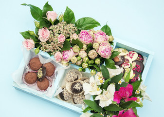 candy handmade decorated in a wooden box with fresh flowers bouquet