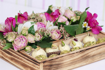 candy handmade decorated in a wooden box with fresh flowers bouquet