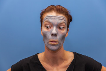 Young woman using a mask on the face in the bathroom
