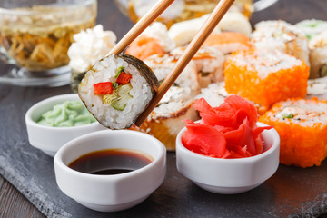 Chopsticks holding roll Philadelphia with marinated rice, cheese Philadelphia