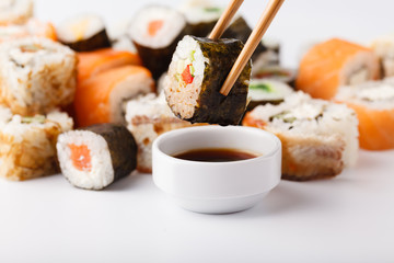 Hand holding sushi Salmon roll in chopsticks with copy space for design work