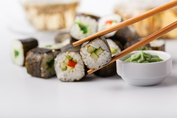 Chopsticks holding roll Philadelphia with marinated rice, cheese Philadelphia