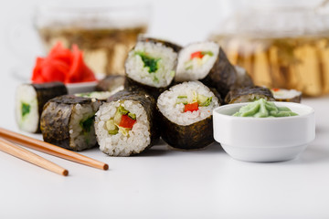 Fresh and delicious maki and nigiri sushi rolls and green tea glass